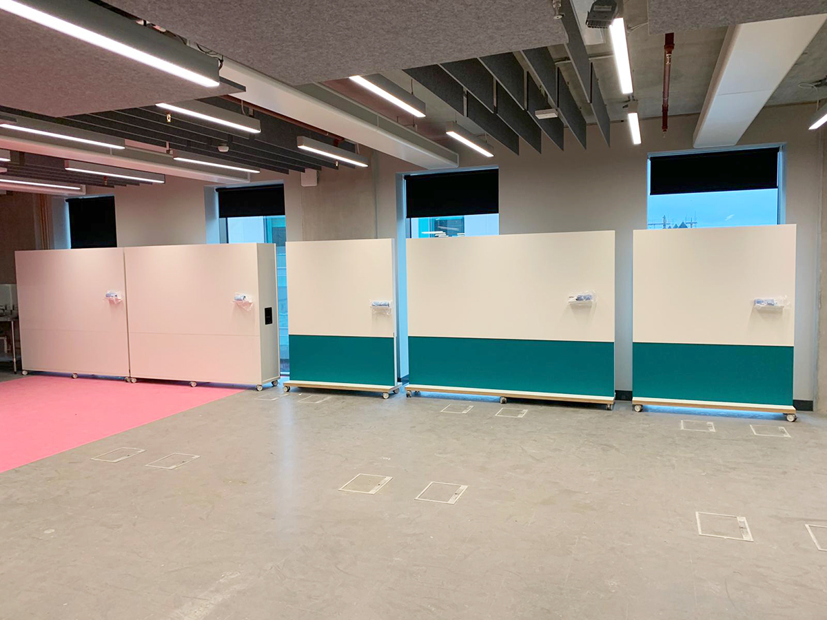 Mobile and freestanding whiteboards pushed together to make a long wall