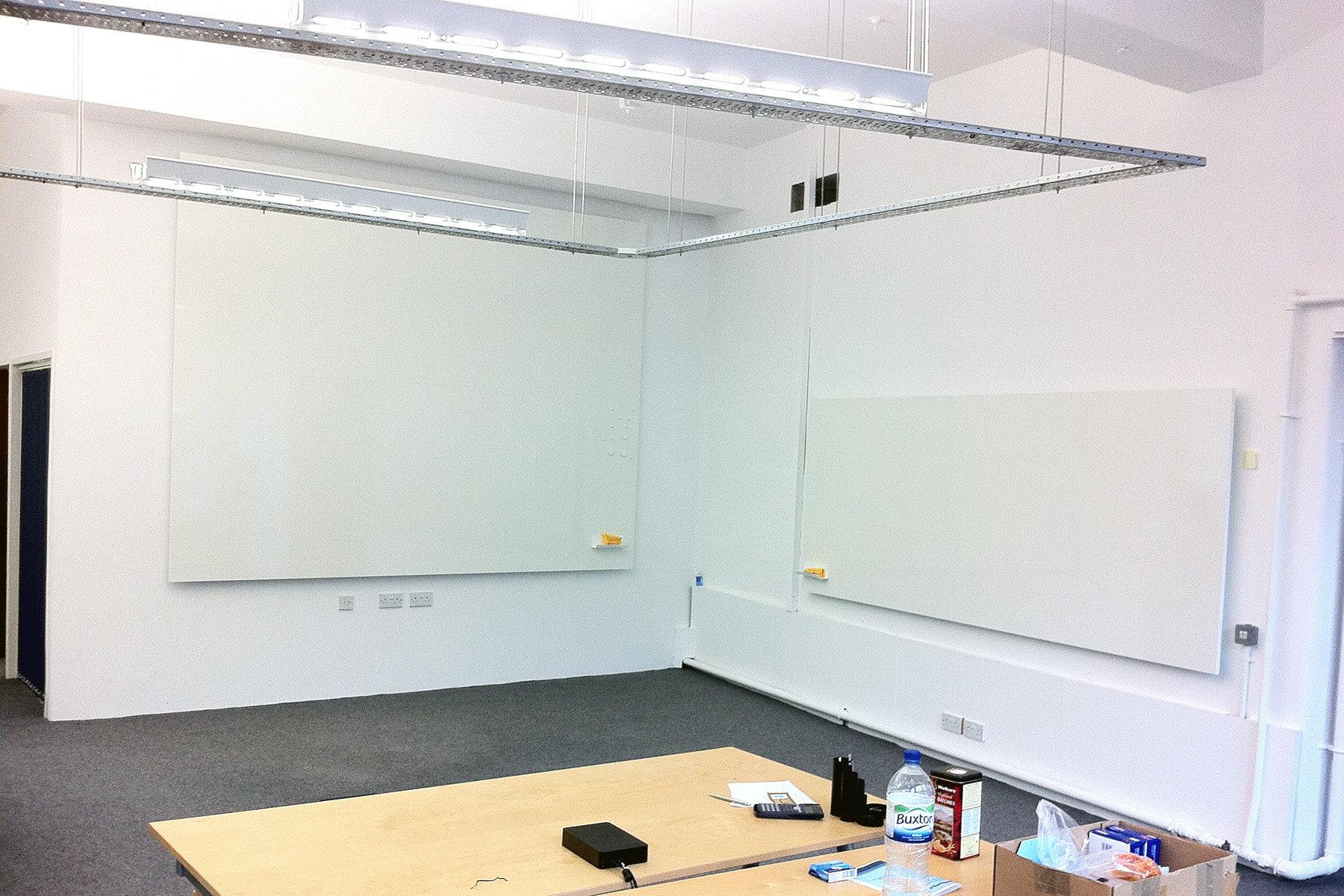 Frameless Whiteboard in two sizes on adjacent walls in the corner of an office