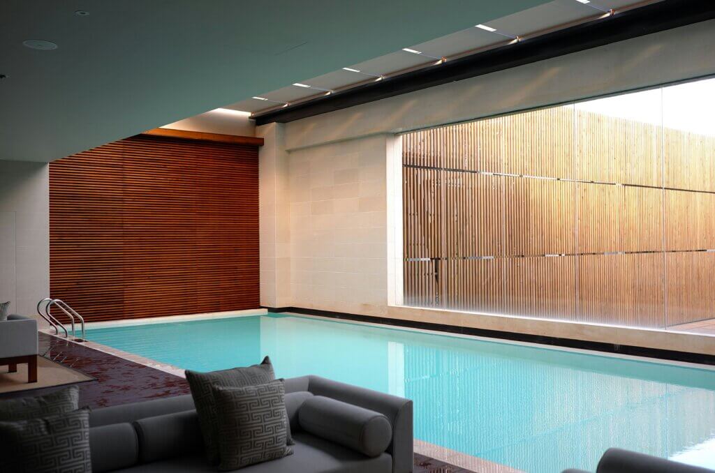 Photo by Li Yang on unsplash.com two grey sofas near an indoor pool in a hotel