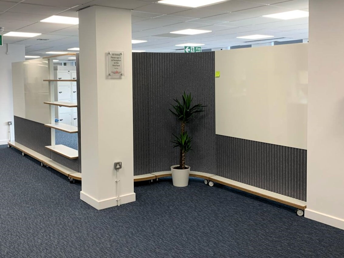 Mobile S-shaped wall using curved dividers on wheels with straight mobile sections.