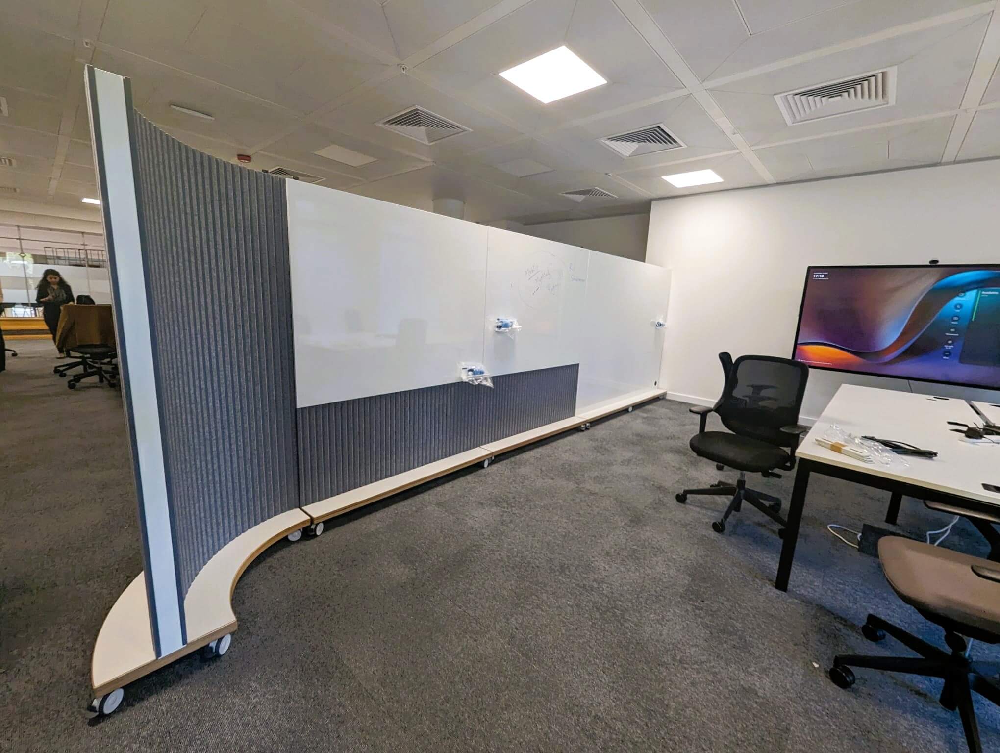 ThinkingWall curved room divider on wheels with acoustic straight dividers separating an open plan office